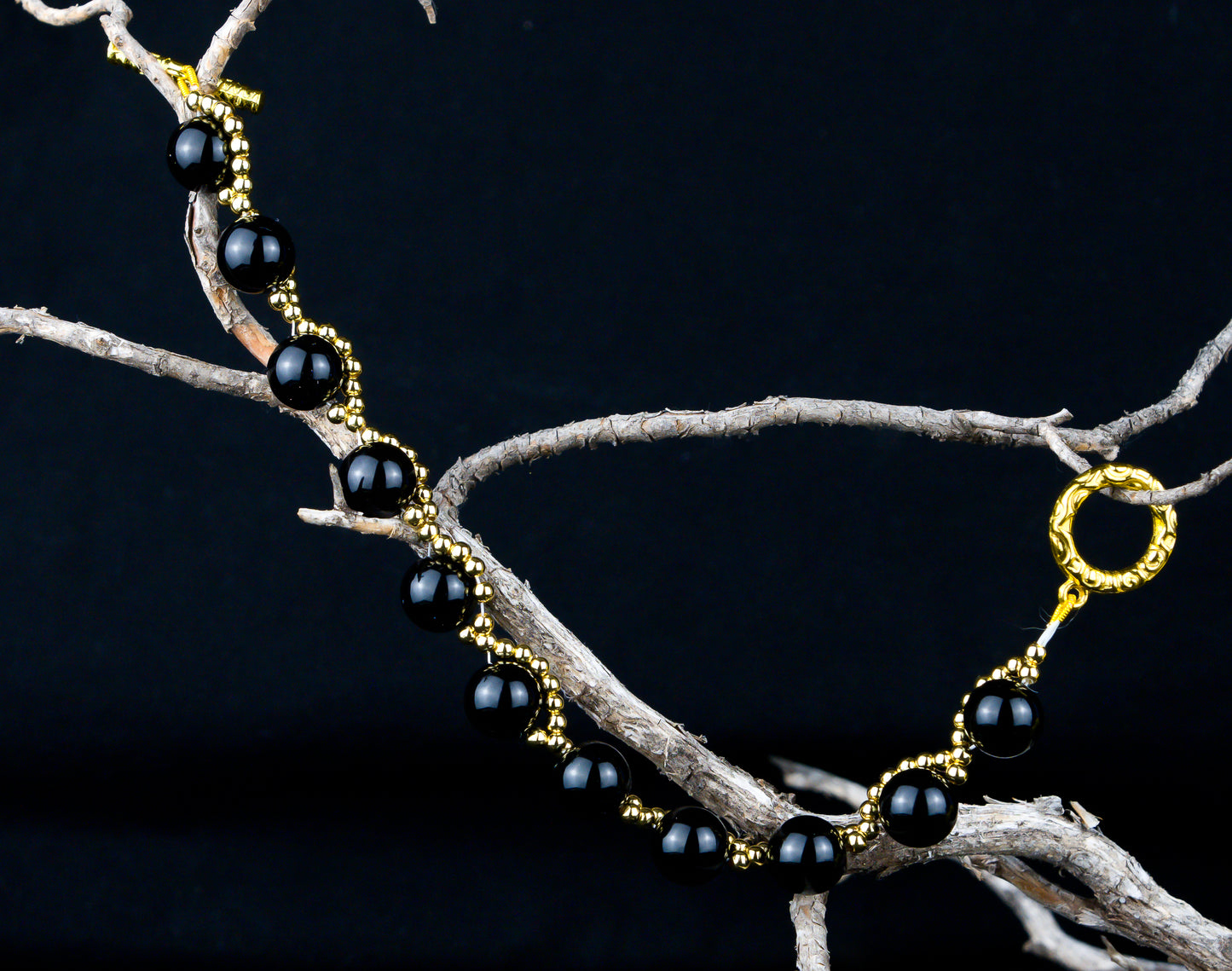 #15-46-51     7.5 inch Black Onyx Bracelet with Imitation Gold Beads and T-Bar and Round Clasp.